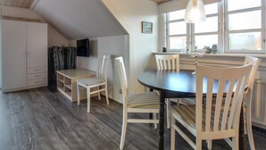 A cozy dining area with a round table, white chairs, and a hanging light fixture. - "Gæsling" - 1.6km from the sea by Interhome (Skagen)