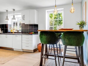 Eine moderne Küche mit weißen Schränken, einer schwarzen Arbeitsplatte und einem Fenster, das für natürliches Licht sorgt.