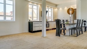 Una cocina amplia con comedor, ventanas grandes y una lámpara de techo moderna.