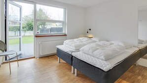 A bedroom with a bed, a chair, a window, and a radiator.