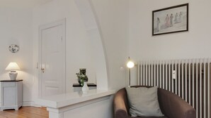 A modern living room with a brown leather sofa, a white console table, a white door, and a framed picture on the wall. - "Gyrth" - 250m from the sea by Interhome (Skagen)
