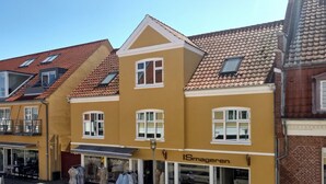 A yellow building with a sign reading "ISmageren" and a storefront with clothing items displayed outside. - "Gyrth" - 250m from the sea by Interhome (Skagen)
