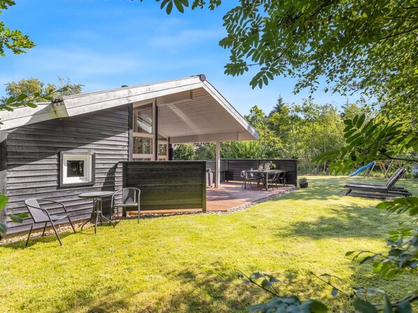 A modern house with a patio, outdoor seating, and a slide.