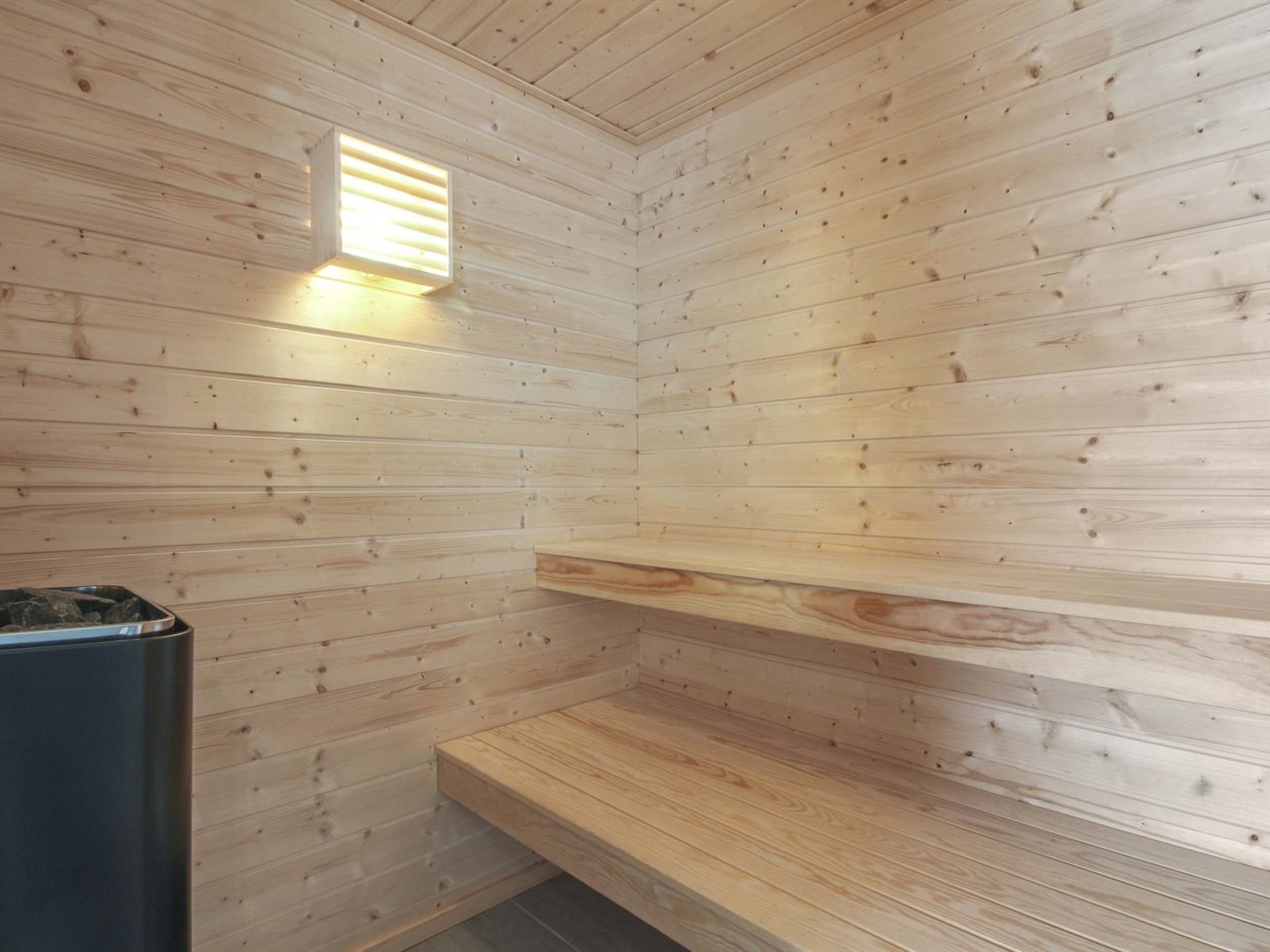 Un sauna en bois, doté d’un banc et d’une petite fenêtre pour assurer la ventilation.