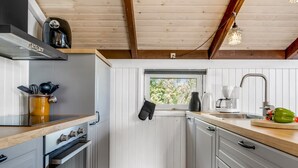 A compact kitchen with wooden beams, a window, and a small window sill. - "Eliana" - 350m from the sea by Interhome (Strandby)