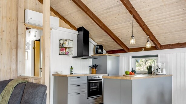 A modern kitchen with a central island, built-in oven, and hanging pendant lights. - "Eliana" - 350m from the sea by Interhome (Strandby)