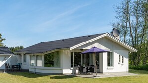 A white building with a covered patio area, a dining table, and chairs. - "Ehm" - 600m from the sea by Interhome (Strandby)