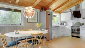 A modern kitchen with white cabinets, stainless steel appliances, and a wooden ceiling. - "Thorger" - 5km from the sea by Interhome (Læsø)