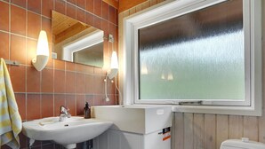 A bathroom with a white sink, a mirror, and a window. - "Thorger" - 5km from the sea by Interhome (Læsø)