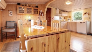 Ein gemütliches Holzhaus-Interieur mit Essbereich, Küche und einer kleinen Sitzecke.