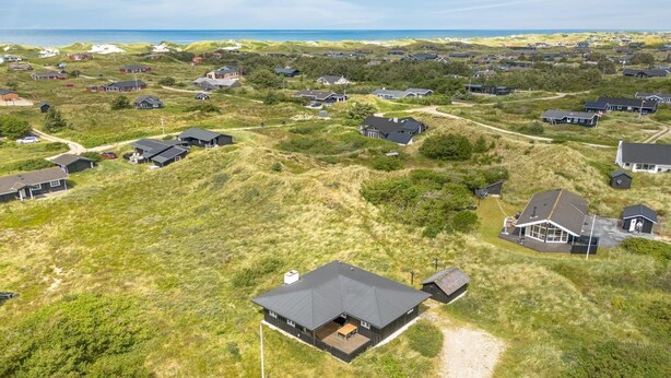 An aerial view of a residential area with houses, a large open space, and a path leading to a building with a dark roof. - "Iken" - 500m from the sea by Interhome (Ringkøbing)