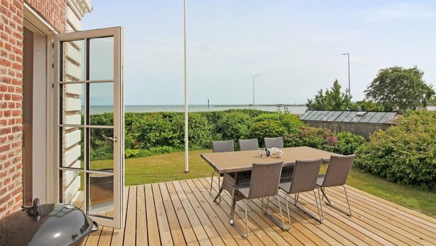A patio with a table and chairs, a grill, and a view of the sea. - "Kosara" - 50m from the sea by Interhome (Frederikshavn)
