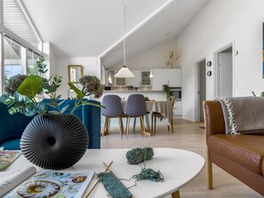 Una sala de estar moderna con un sofá, una mesa de centro y un comedor con sillas y una mesa.