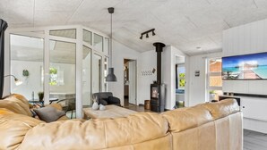 A modern living room with a leather sofa, a TV, and a fireplace. - "Jonke" - 800m from the sea by Interhome (Blåvand)