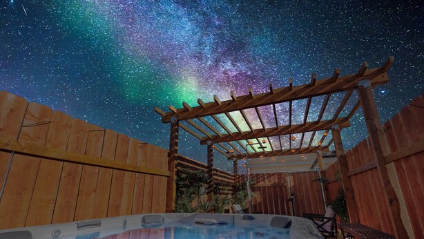 A hot tub under a wooden pergola with a starry night sky. - Summer Relax & Unwind @ Genesis Oasis - Wifi + Spa! Pet Friendly! (Joshua Tree)