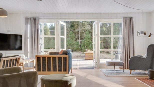 A spacious living room with a large TV, comfortable seating, and a view through large windows. - "Harpa" - 2.5km from the sea by Interhome (Blåvand)