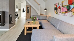 A modern living room with a grey sofa, a wooden coffee table, and a staircase leading to an upper level. - "Todorka" - 800m from the sea by Interhome (Blåvand)