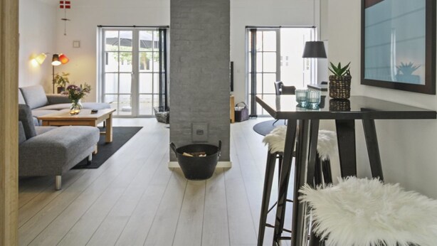 A modern living room with a fireplace, a dining area with a table and chairs, and a large window. - "Todorka" - 800m from the sea by Interhome (Blåvand)