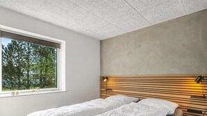 A bedroom with a bed, a window, and a headboard with a light fixture. - "Gunny" - 500m to the fjord by Interhome (Blåvand)