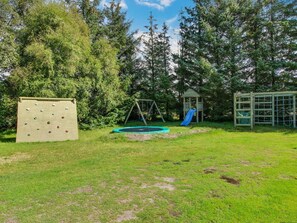 A playground with a climbing wall, swing set, slide, and a small playhouse. - "Patrik" - 1.4km from the sea by Interhome (Blåvand)