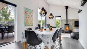 A modern dining area with a large table, black chairs, and pendant lights. - "Siegfried" - 500m from the sea by Interhome (Blåvand)