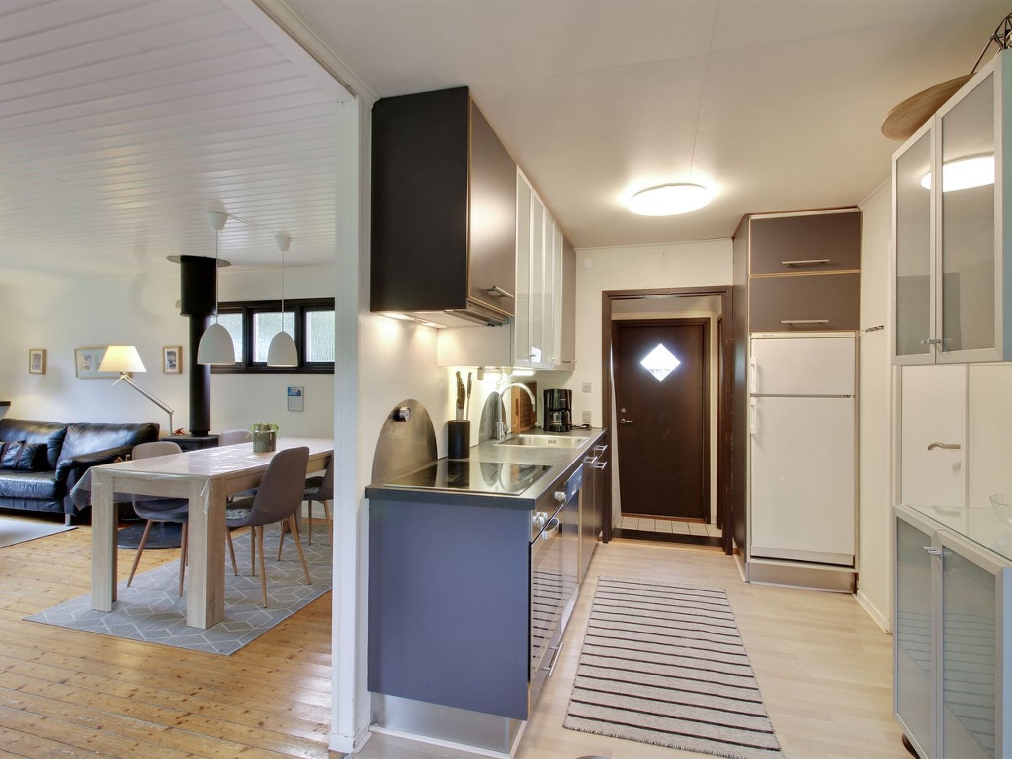 Une cuisine moderne dotée d’un îlot central, de meubles blancs et d’un four encastré.