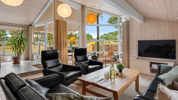 A modern living room with leather sofas, a wooden coffee table, and large windows offering a view of the outdoors. - "Birgita" - 700m from the sea by Interhome (Vejers Strand)