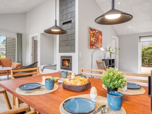 A dining area with a wooden table, blue plates, and a fireplace. - "Alena" - 1km from the sea by Interhome (Vejers Strand)