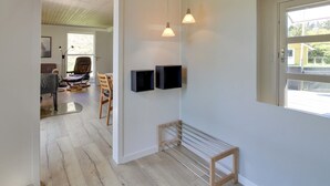 Ein modernes Interieur mit Holzboden, einer Bank und einem an der Wand montierten Fernseher.