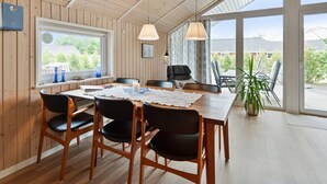 A dining area with a wooden table, black chairs, and a large window offering a view of the outdoors.