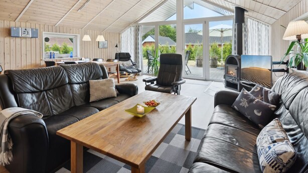 A spacious living area with leather sofas, a wooden coffee table, and a fireplace.