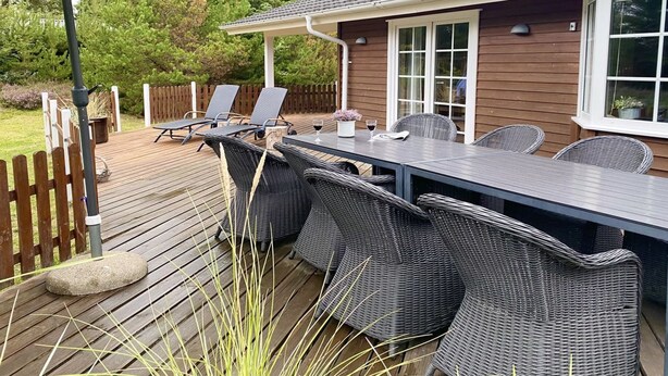 An outdoor patio with a dining table, chairs, and an umbrella. - "Orpah" - 2.5km from the sea by Interhome (Rømø)
