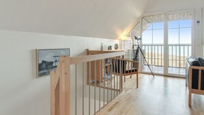A spacious loft with a wooden staircase, a balcony with a view, and a modern living area. - "Deljan" - 3.5km from the sea by Interhome (Rømø)