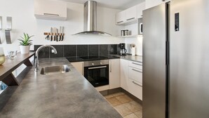A modern kitchen with a stainless steel refrigerator, a built-in oven, a sink, and a range hood. - "Deljan" - 3.5km from the sea by Interhome (Rømø)