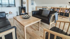 A modern living room with a fireplace, leather furniture, a wooden coffee table, and a bookshelf. - "Deljan" - 3.5km from the sea by Interhome (Rømø)