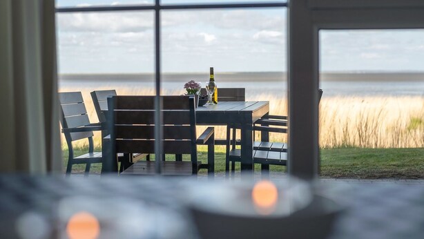A table with chairs and a bottle, facing a view of the water. - "Deljan" - 3.5km from the sea by Interhome (Rømø)
