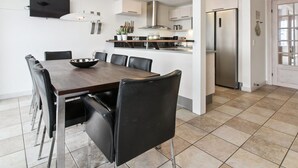 A modern kitchen with a dining area, stainless steel appliances, and a tiled floor. - "Deljan" - 3.5km from the sea by Interhome (Rømø)