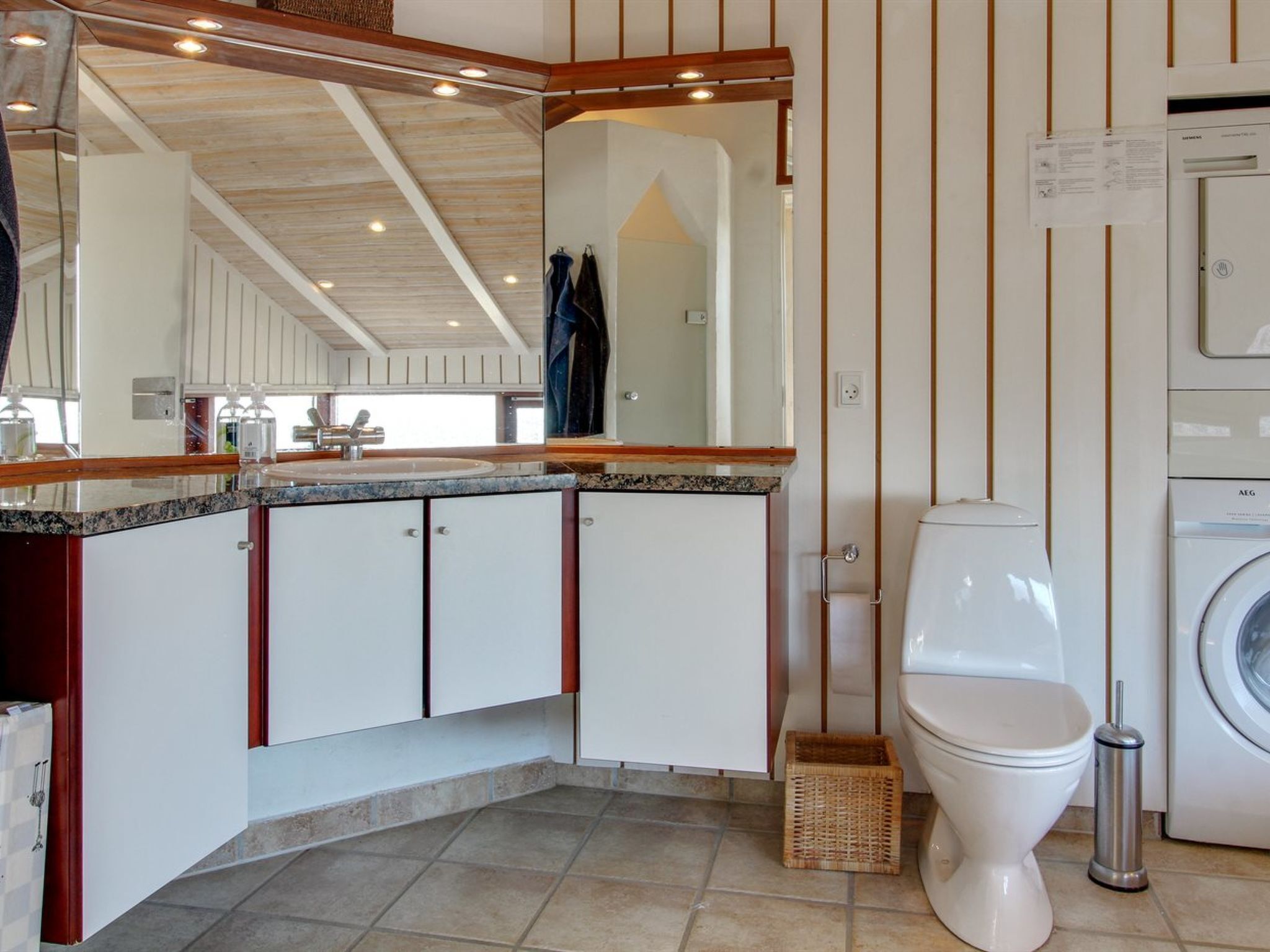 A modern bathroom with a built-in sink, a toilet, and a washing machine.