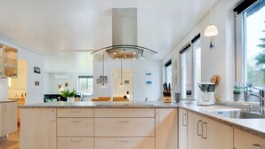 Una cocina moderna con una isla grande, electrodomésticos de acero inoxidable y mucha encimera.