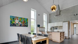 A modern kitchen with white cabinets, a built-in oven, and a microwave.