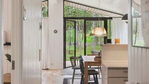 A modern interior with a dining area, large windows, and a view of the forest. - "Santuzza" - 3.9km from the sea by Interhome (Rømø)