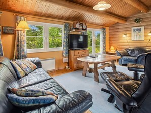A cozy cabin interior with a leather sofa, a dining table, and a television. - "Thorbergh" - 2km from the sea by Interhome (Rømø)