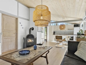 A modern interior with a fireplace, dining table, and a cozy seating area.