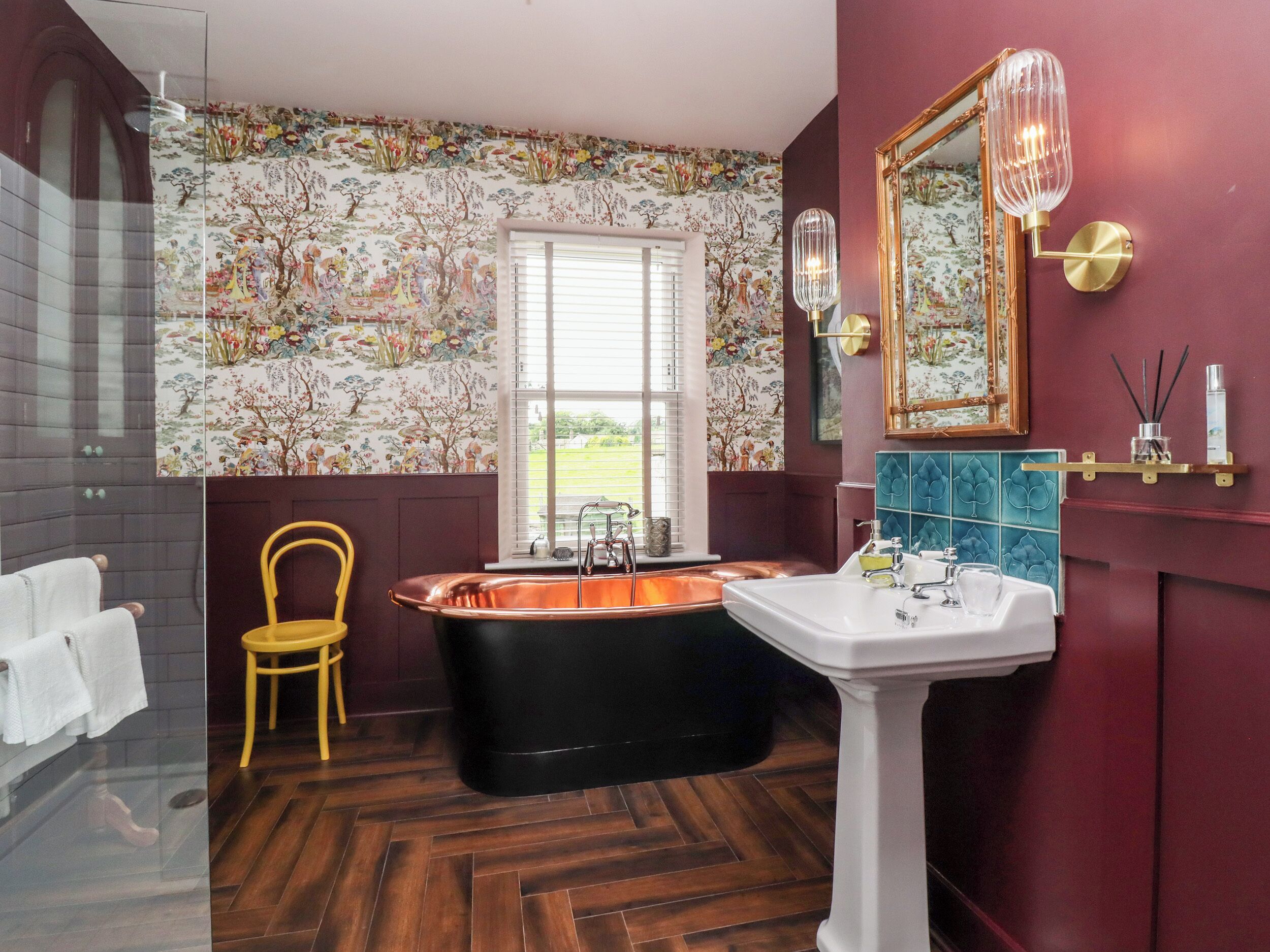 A bathroom with a bathtub, a sink, and a chair.