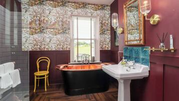 A bathroom with a bathtub, a sink, and a chair.