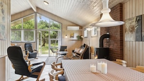 Une pièce chaleureuse avec un plafond en bois, une grande table décorée de bougies et une cheminée.