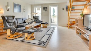 A modern living room with a sofa, chairs, a coffee table, and a TV stand. - "Helvig" - 2.3km from the sea by Interhome (Rømø)