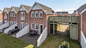 Een rij bakstenen huizen met witte details en puntige daken.