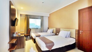 A hotel room with two beds, a desk with a chair, a TV mounted on the wall, and a large window with curtains. - Lorin Dwangsa Solo Hotel (Surakarta)
