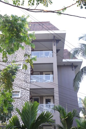 Un immeuble à plusieurs étages, doté d’une façade en pierre et de balcons.